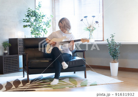 白いエレキギターを弾く若い女性 91631932