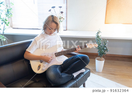 白いエレキギターを弾く若い女性 91632364