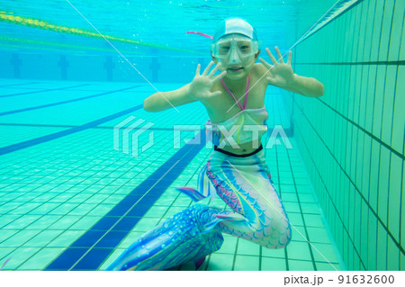 温水プールでマーメイドを練習している小学生の女の子の水中写真 91632600