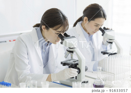 顕微鏡を覗く白衣の女性 研究 実験 91633057
