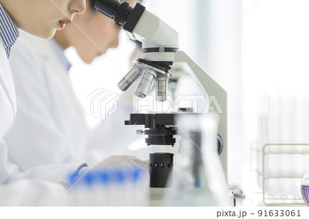 顕微鏡を覗く白衣の女性 研究 実験 91633061