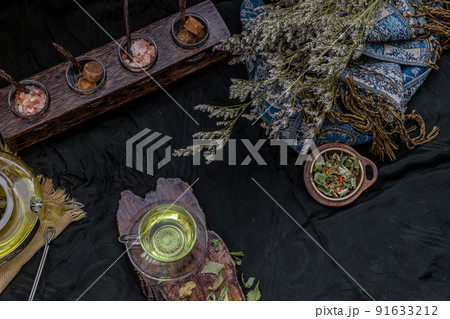 A Beautiful composition with a hot pandan leaf tea with indian marsh fleabane plant leaves and Safflower dried (Saffron substitute) at dark background. 91633212
