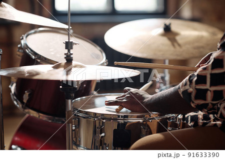 Close-up of African drummer playing rock music on drums set with sticks Close-up of African drummer playing rock music on drums set with sticks 91633390
