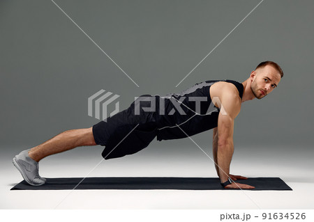 Handsome man doing plank exercise on floor indoors Handsome man doing plank exercise on floor indoors 91634526