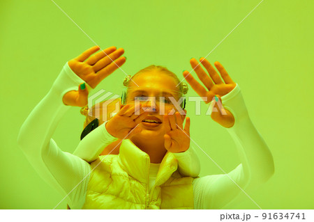 Woman with little girl in futuristic costume wearing smart led glasses of virtual reality while touching air. Augmented reality game, future technology, AI concept. VR. Neon light. Woman with little girl in futuristic costume wearing smart led glasses of virtual reality while touching air. Augmented reality game, future technology, AI concept. VR. Neon light. 91634741