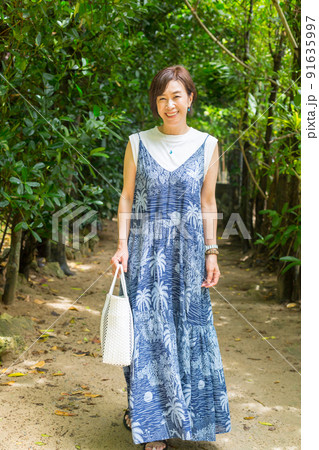 樹齢数百年のフクギの木が並ぶ砂の道を歩く旅ガール、沖縄のパワースポット「フクギ並木」 樹齢数百年のフクギの木が並ぶ砂の道を歩く旅ガール、沖縄のパワースポット「フクギ並木」 91635997