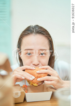 ハンバーガーを食べる女性 91636027