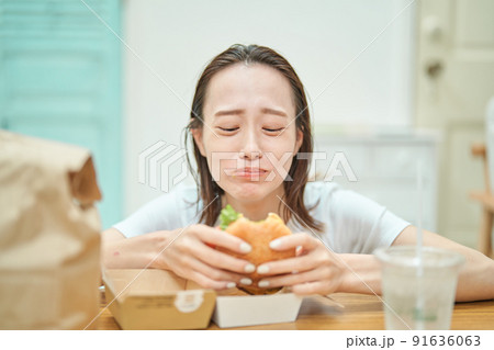 ハンバーガーを食べる女性 91636063