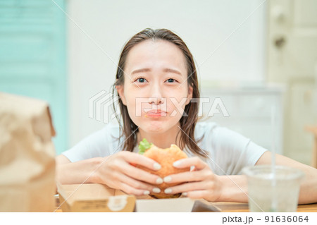ハンバーガーを食べる女性 91636064