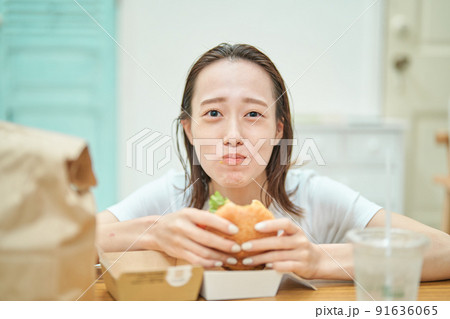 ハンバーガーを食べる女性 91636065
