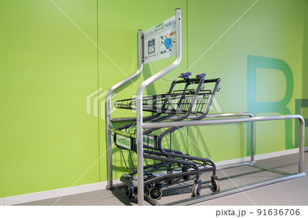 スーパーの入口に鎖で連結されたコイン式 ショッピングカート（ 硬貨投入式 ショッピングカート） 91636706