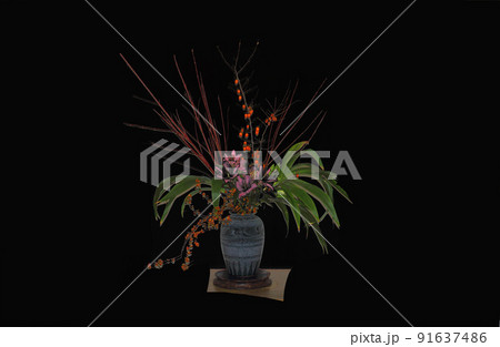 赤い実とグリーンの葉と枝は素敵な花瓶に生けられて、このバランスこの空間が和 赤い実とグリーンの葉と枝は素敵な花瓶に生けられて、このバランスこの空間が和 91637486