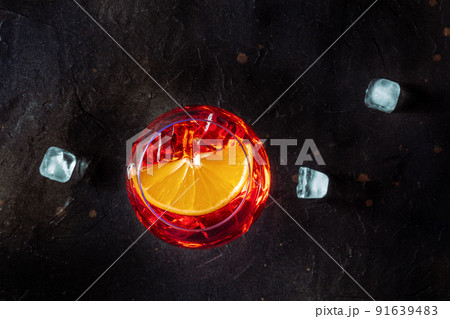 Aperol cocktail with an orange slice and ice cubes, Italian summer cold drink 91639483