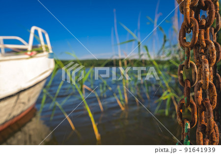 Rusted chain and boat on the lakeshore 91641939