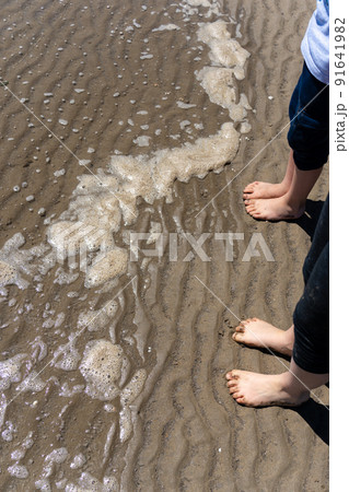 Kids feet in water on the beach 91641982