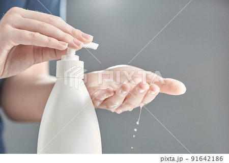 Female hands using hand sanitizer gel pump dispenser. Drops of gel close-up. Female hands using hand sanitizer gel pump dispenser. Drops of gel close-up. 91642186