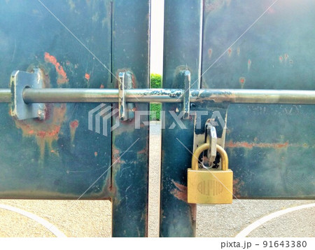 古い黒い門に付いている金色の錠前 古い黒い門に付いている金色の錠前 91643380