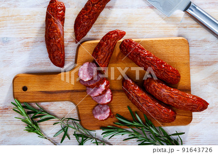 Sliced half-smoked sausages susena on wooden table. Traditional Chezh meat products 91643726