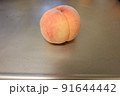 金属板の上にあるピンクの桃 91644442
