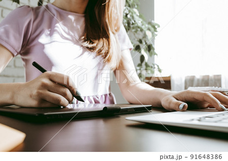 Close up of female graphic designer drawing sketches on graphic tablet 91648386