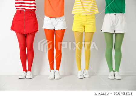 Women wearing bright tights near white wall, closeup Women wearing bright tights near white wall, closeup 91648813