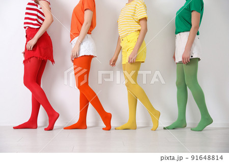 Women wearing bright tights near white wall, closeup Women wearing bright tights near white wall, closeup 91648814