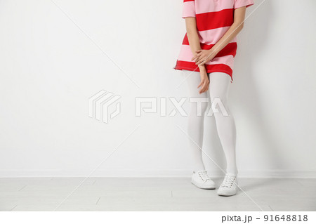 Woman wearing tights near white wall, closeup. Space for text 91648818