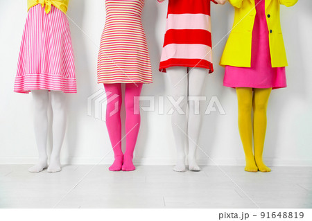 Women wearing colorful tights near white wall, closeup 91648819