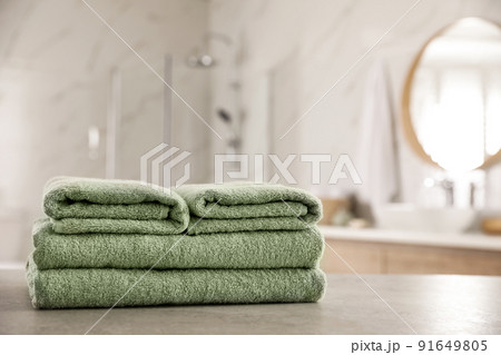 Stack of clean towels on table in bathroom 91649805