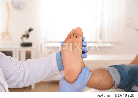 Male orthopedist checking patient's foot in clinic, closeup 91649829