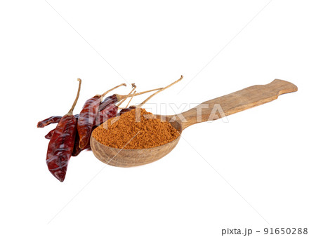 Wooden spoon full of ground red pepper and pepper pods on a white background. Wooden spoon full of ground red pepper and pepper pods on a white background. 91650288