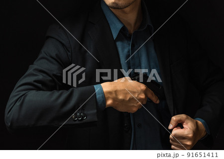 拳銃を構えるスーツの人物 91651411