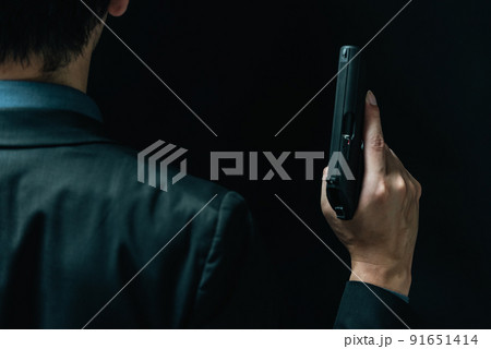 拳銃を構えるスーツの人物 拳銃を構えるスーツの人物 91651414