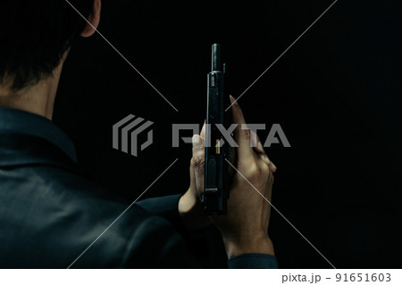 拳銃を構えるスーツの人物 91651603