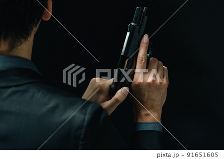 拳銃を構えるスーツの人物 91651605