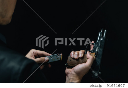 拳銃を構えるスーツの人物 91651607