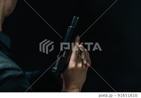 拳銃を構えるスーツの人物 91651610