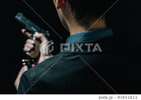 拳銃を構えるスーツの人物 91651611