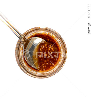 Spoon inside a glass jar with Bavarian mustard. 91651636