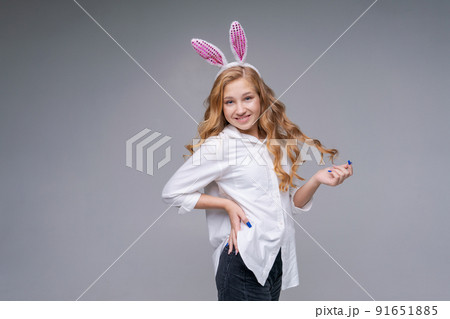 Young beautiful woman in cute easter bunny ears makes a normal gesture, plays Young beautiful woman in cute easter bunny ears makes a normal gesture, plays 91651885