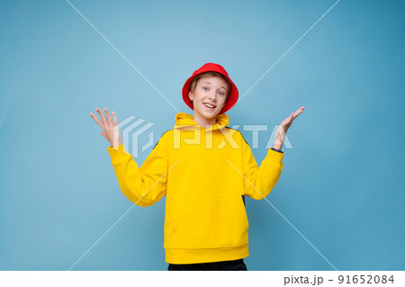 Wow, this is incredible. Shocked caucasian teenager in red hat and yellow 91652084