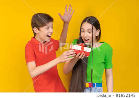 Smiling couple two friends guy and girl in casual clothes isolated on yellow 91652145