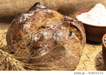 Round bread close-up. Freshly baked sourdough bread with a golden crust. Baker shop context with delicious bread. 91653172