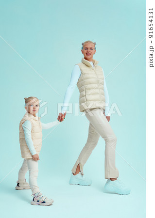 Young girl kid child with mother wearing smart glasses and explore alternative reality. Cyber space and virtual gaming. Discover future technology on blue background 91654131