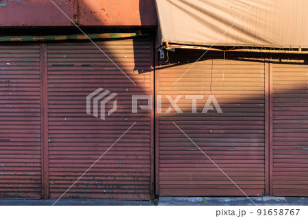 廃業した商店の閉鎖されたシャッター 91658767