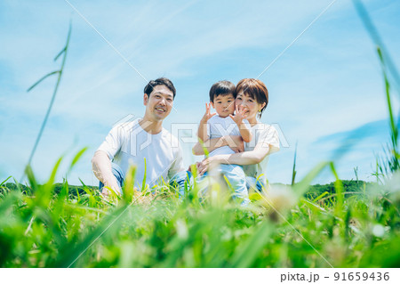 晴天の緑地に座る親子 晴天の緑地に座る親子 91659436