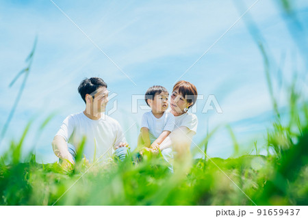 晴天の緑地に座る親子 晴天の緑地に座る親子 91659437