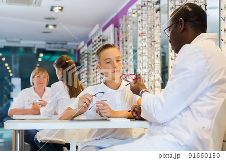 Teenager looking for glasses with African-American optician 91660130