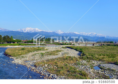 【富山県魚津市】早月橋から望む立山連峰と通過する電車 ※2022年5月4日撮影 【富山県魚津市】早月橋から望む立山連峰と通過する電車 ※2022年5月4日撮影 91660500
