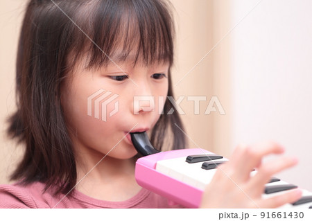 鍵盤ハーモニカを演奏する女の子 91661430